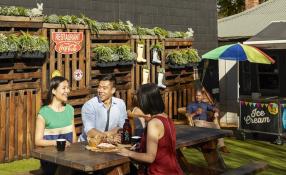 three people enjoying lunch outdoors at a pub